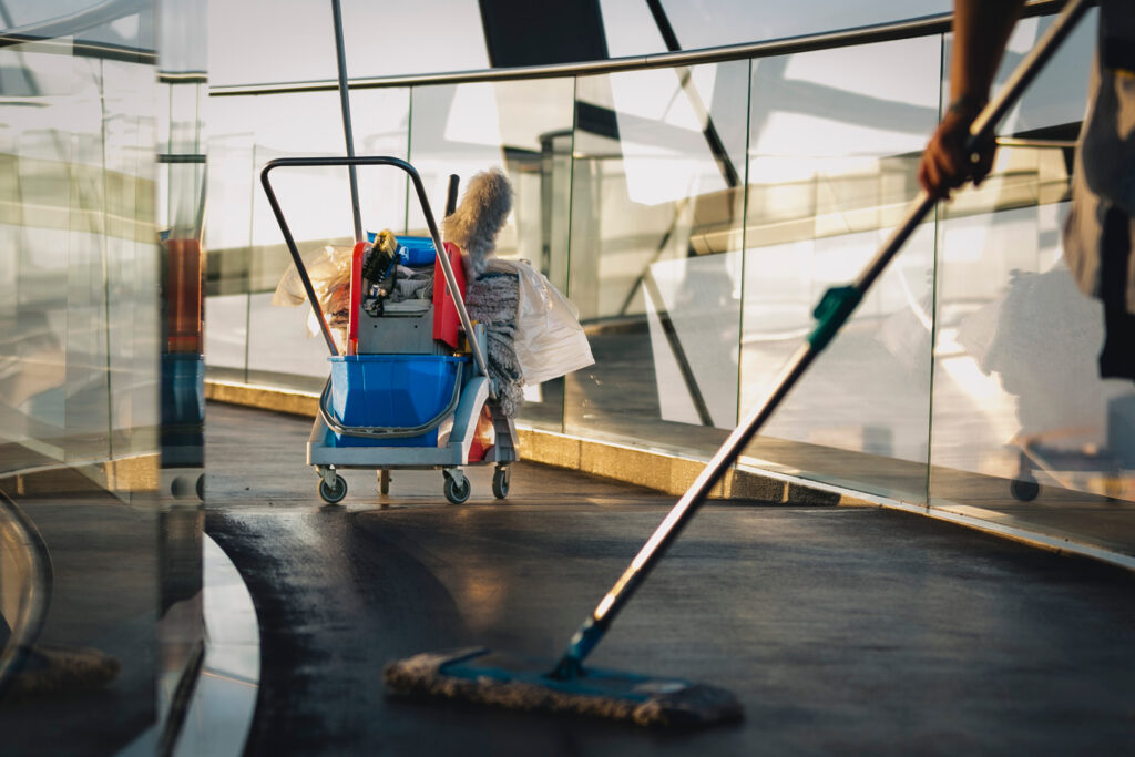 reinigungskraft mit arbeitsmitteln putzt